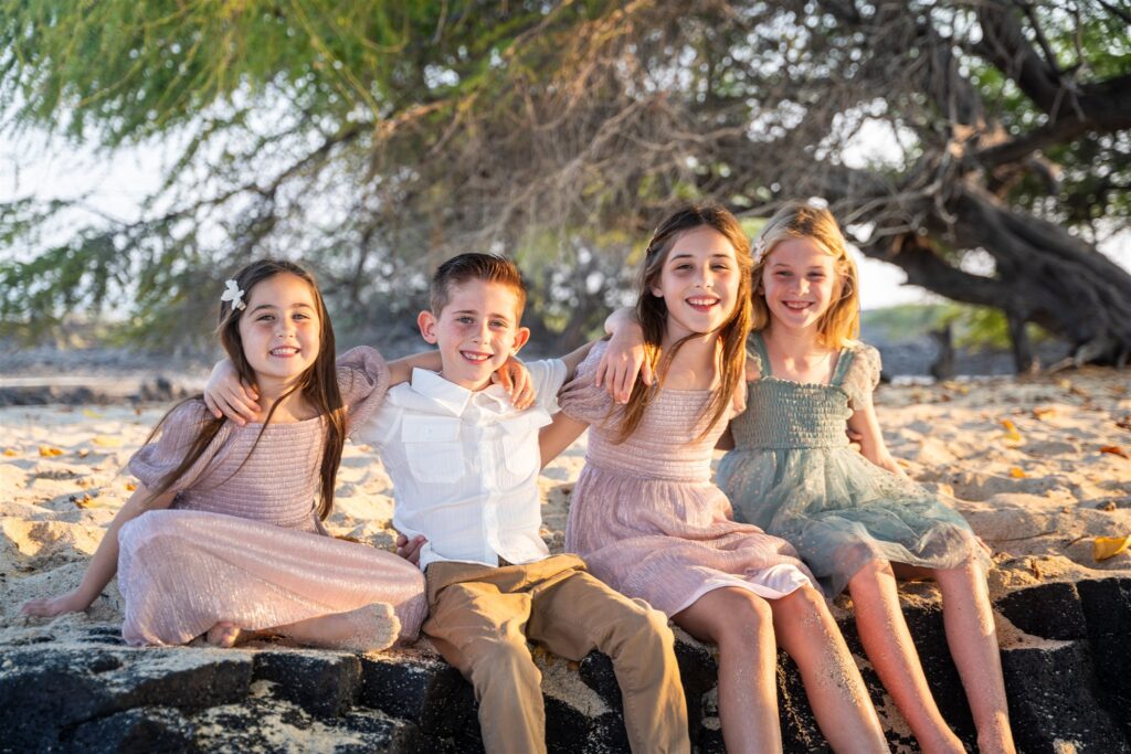 children smiling on hawaii beach showing hawaii family portraits poses with little kids