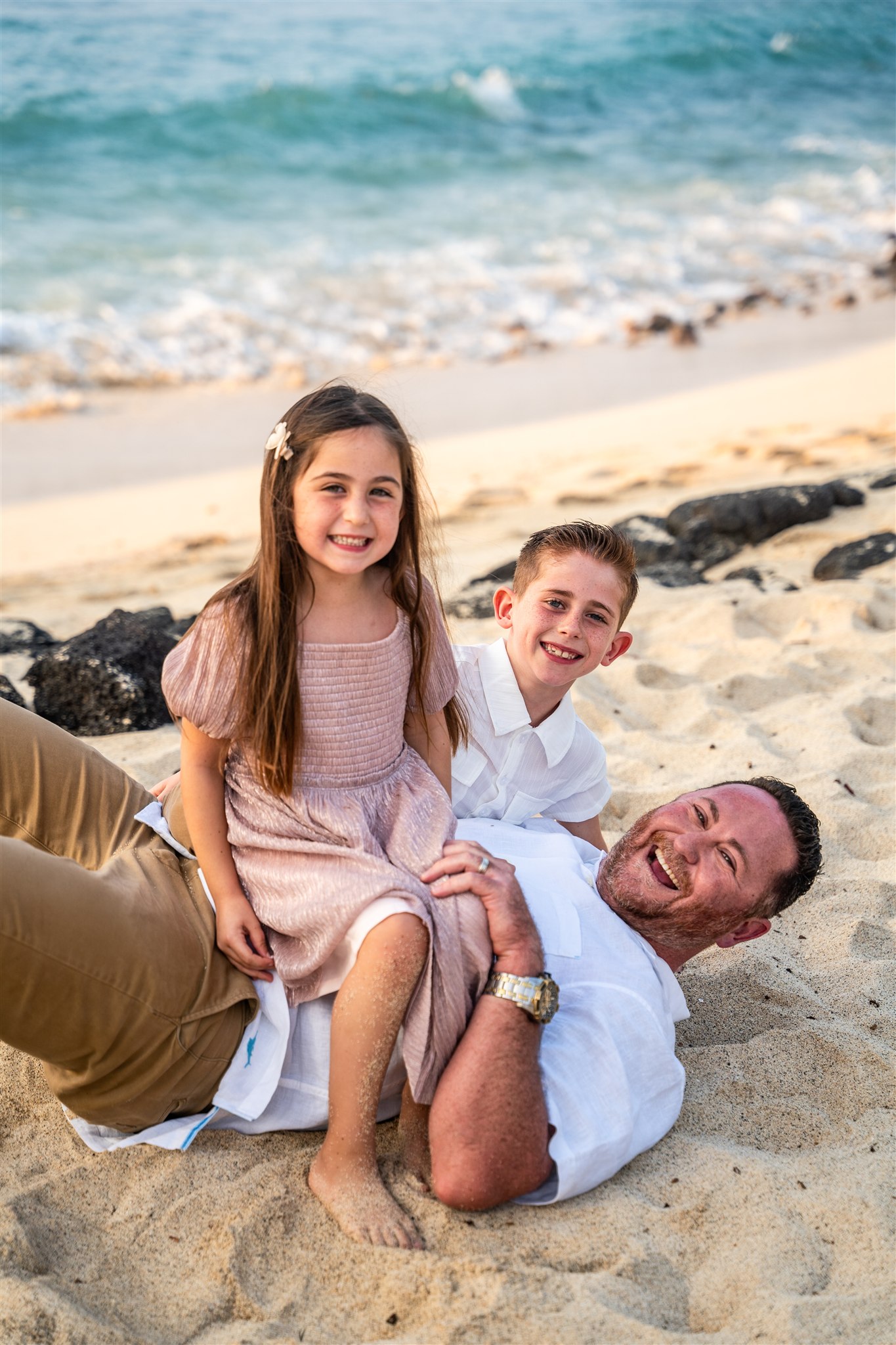 family portraits in hawaii with kids sitting on dad