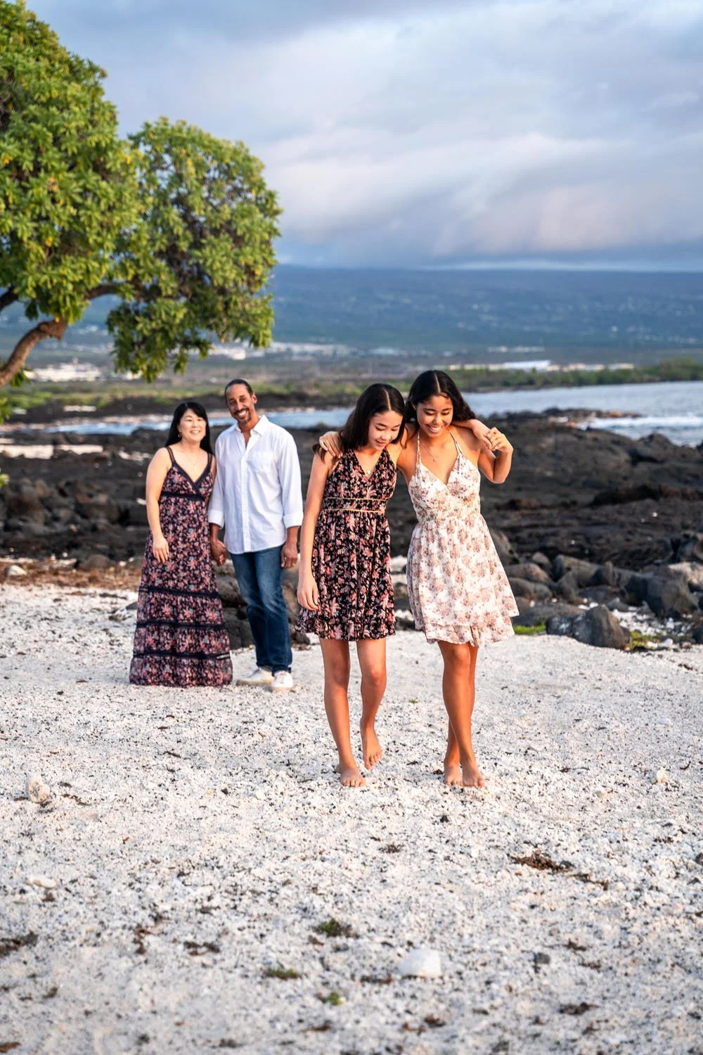 sisters walking together on a white sandy beach on the big island of hawaii