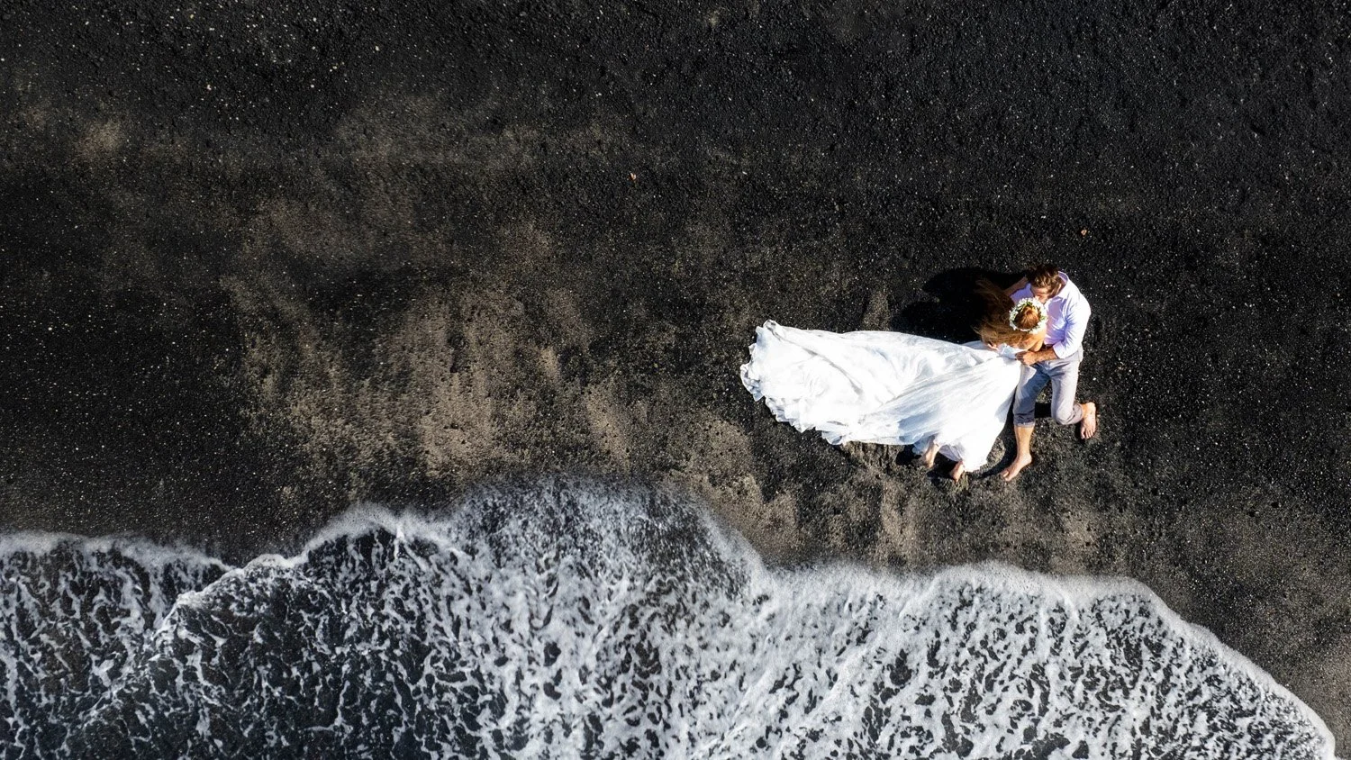 bride and groom on a black sandy beach on the big island of hawaii.jpg