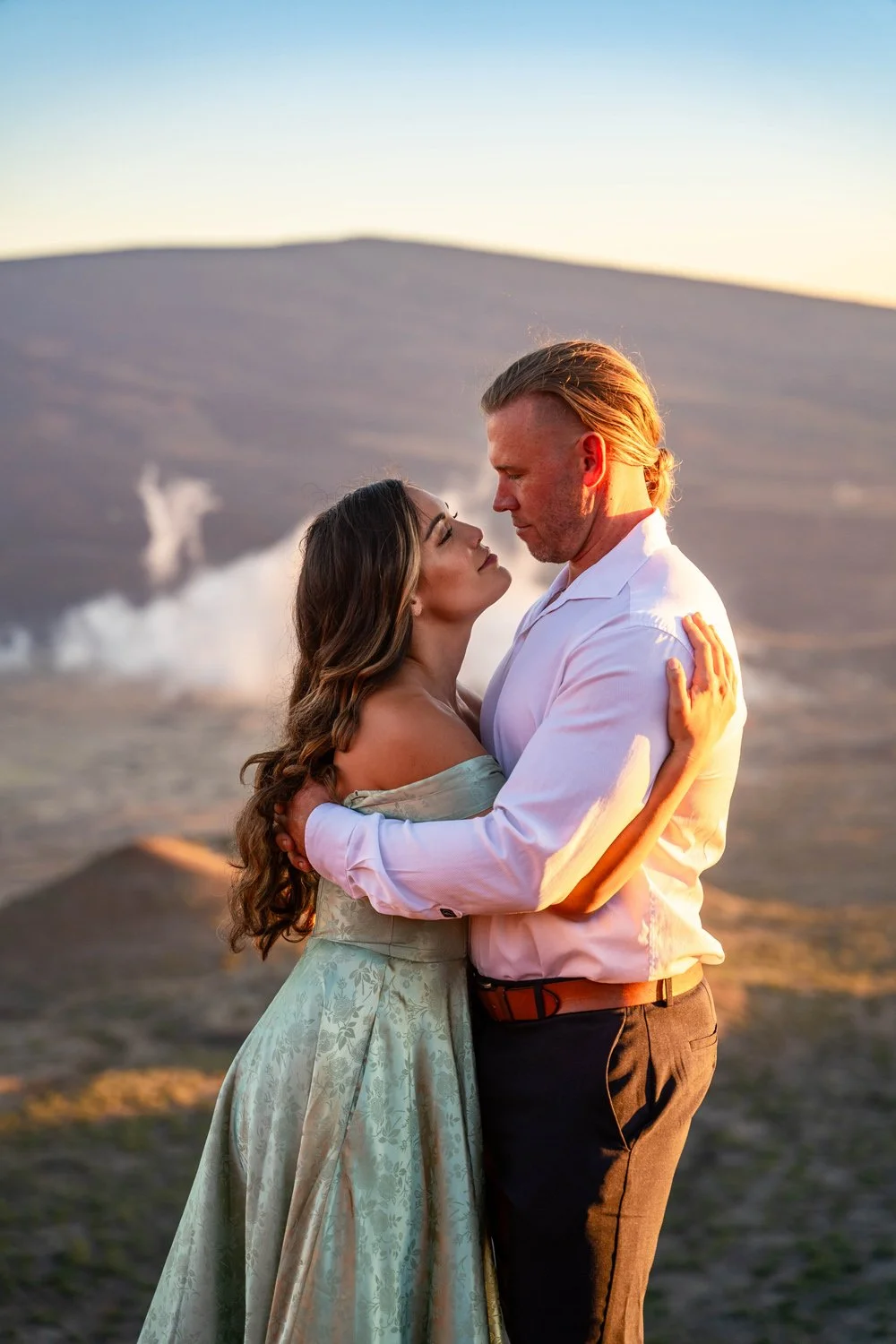 couple embracing in the mountains at sunset for a couples portrait session on the Big Island of Hawaii