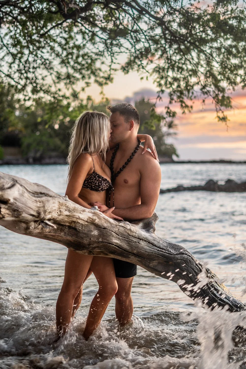 couple embracing and hugging on a white sandy beach during sunset for a couples portrait session on the Big Island of Hawaii