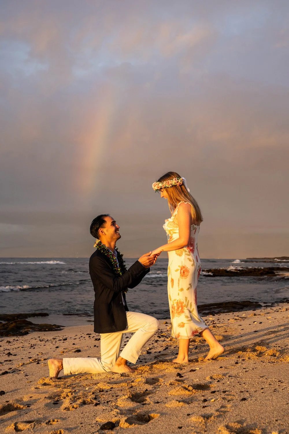 man proposing to girlfriend at the four seasons with a rainbow behind them