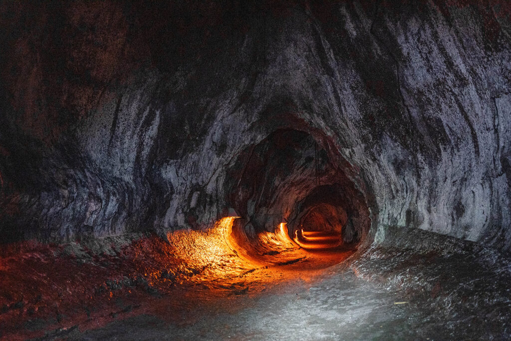 Inside Thurston Lava Tube illuminated by warm light in Hawaii Volcanoes National Park.