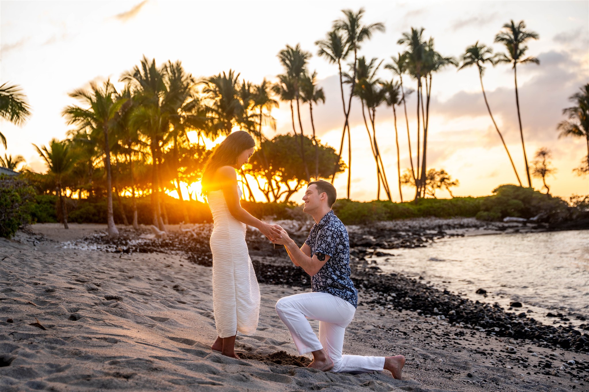 Man proposing on the beach during a romantic Fairmont Orchid proposal at sunset on the Big Island of Hawaii