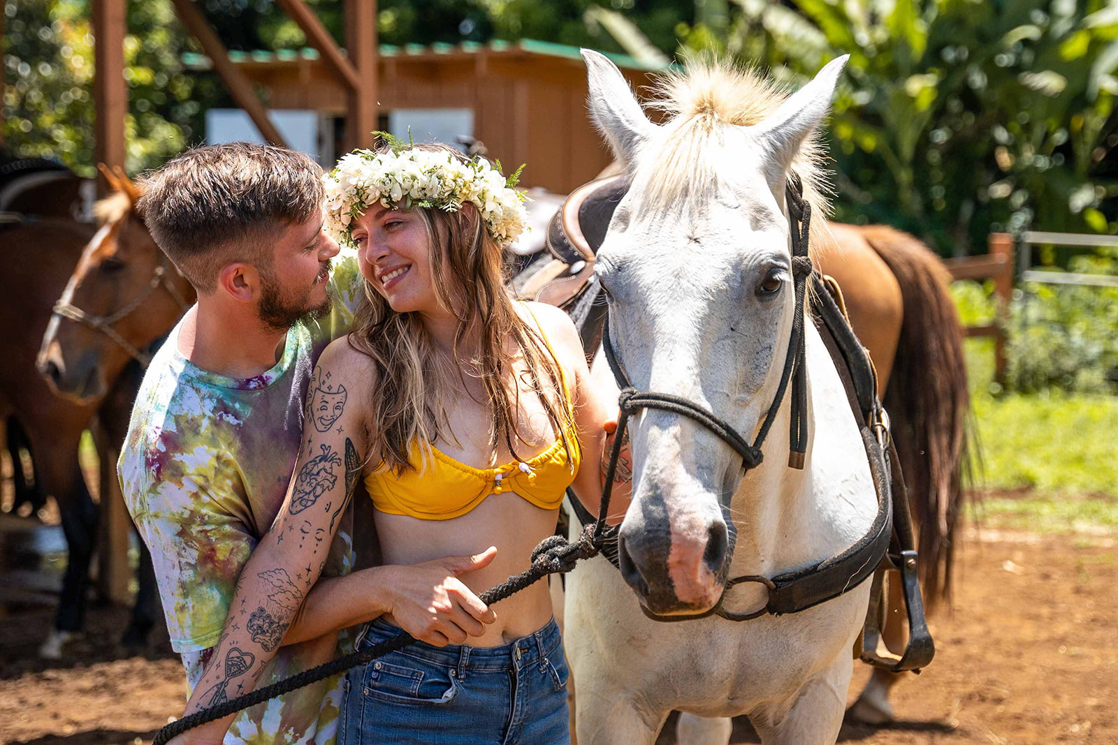 Couple smiling with a white horse after their Hawaii horseback proposal at Wailea Horseback Adventures on the Big Island