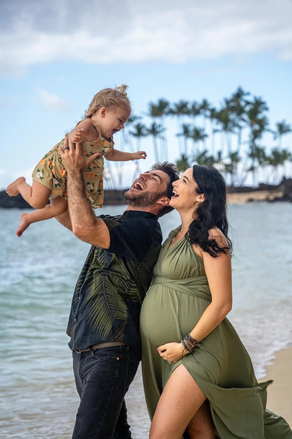 Parents lifting their daughter during a Big Island Hawaii family photo session on the beach.