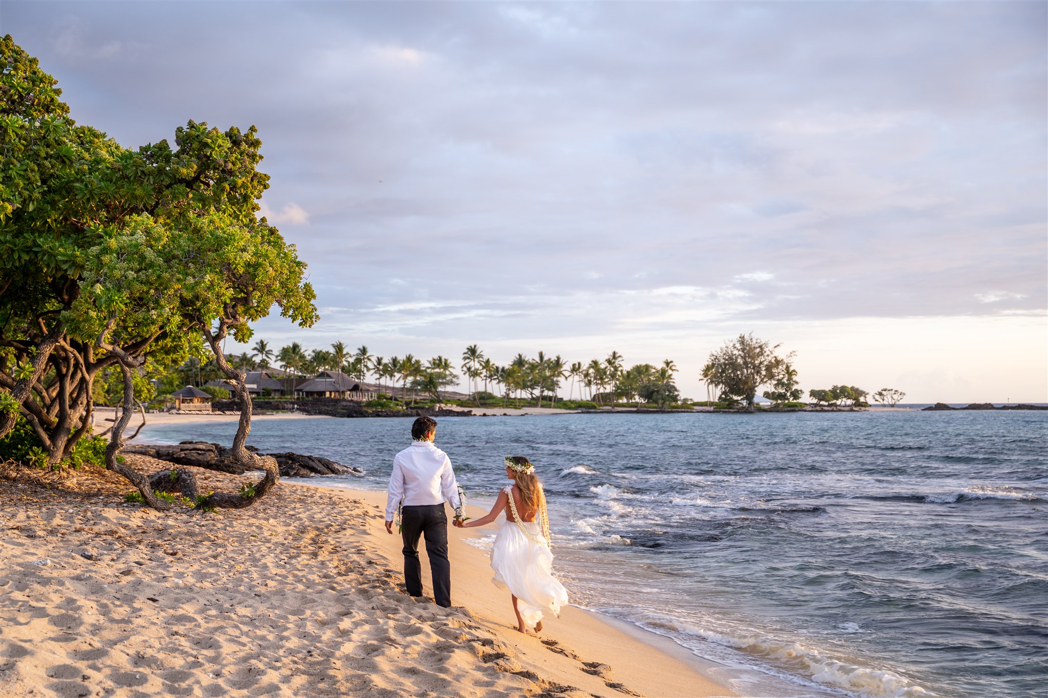 Couple wandering the beach without wondering what to wear for engagement photos in hawaii.