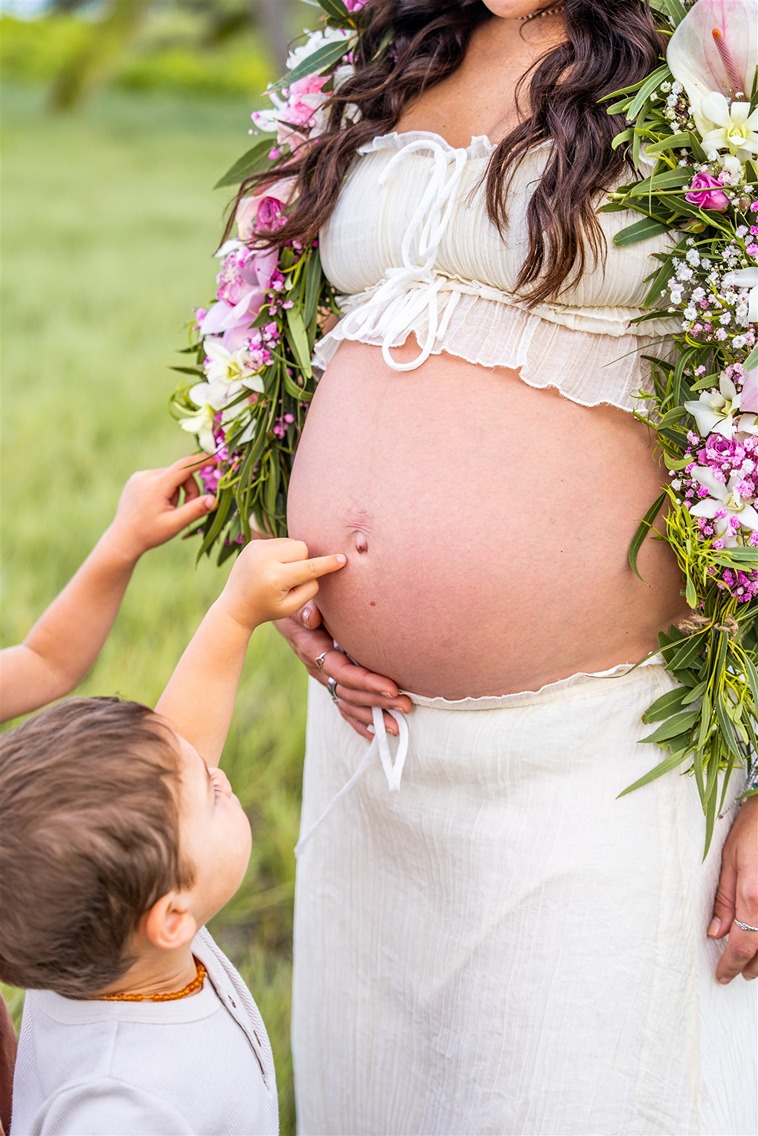 family photography kona photos of the kids touching the bump
