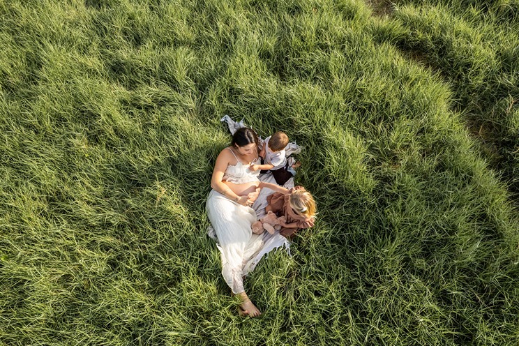 kona hawaii photos of a mom laying in the grass with her two children