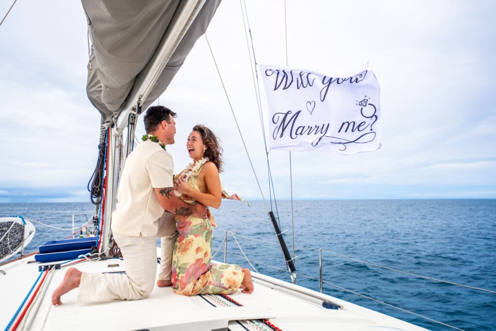 hawaii sailboat proposal with marry me flag